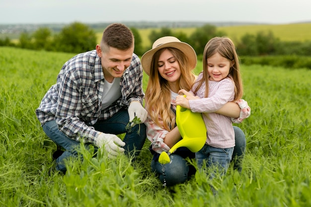 Family nurturing plants together on a farm